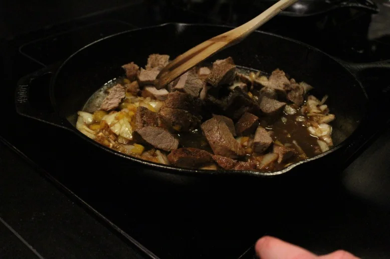 Viande hachée remise dans le chaudron avec les légumes